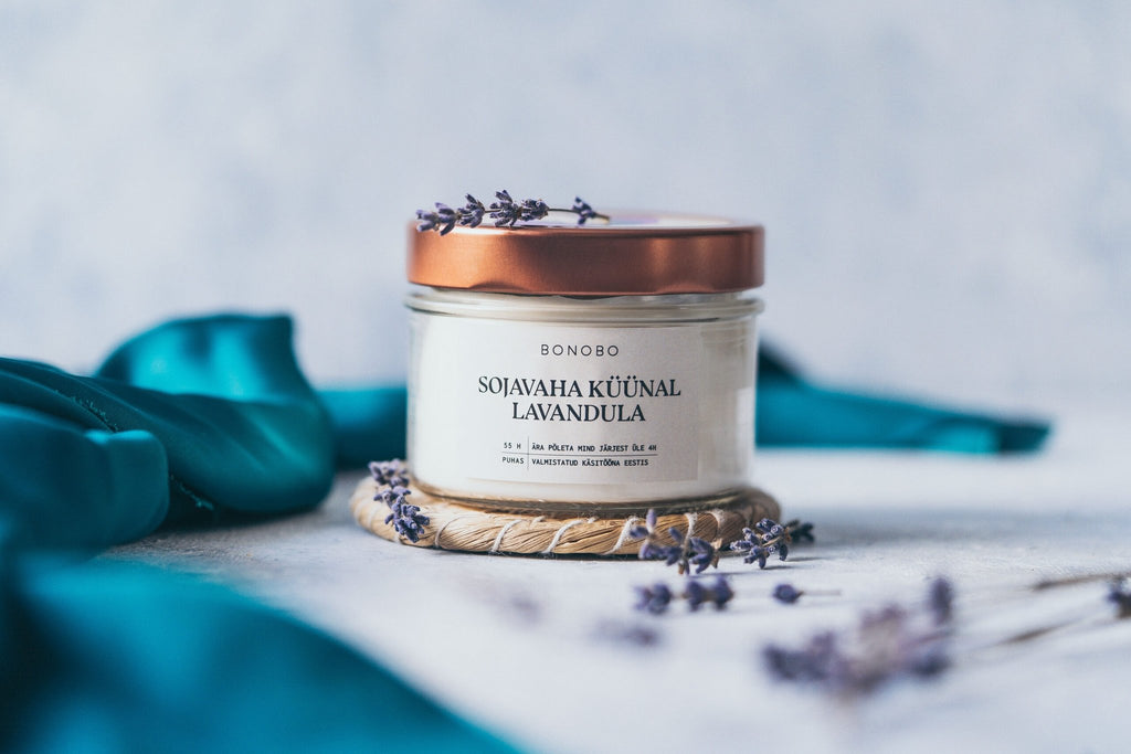 3. BONOBO Scented Candle Lavandula with copper lid, surrounded by lavender sprigs in a serene setting