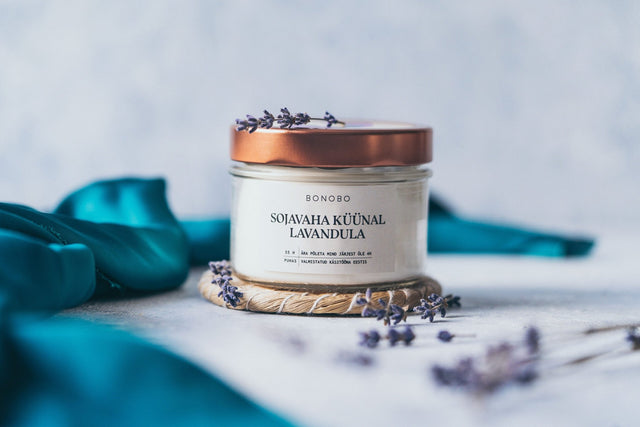 3. BONOBO Scented Candle Lavandula with copper lid, surrounded by lavender sprigs in a serene setting