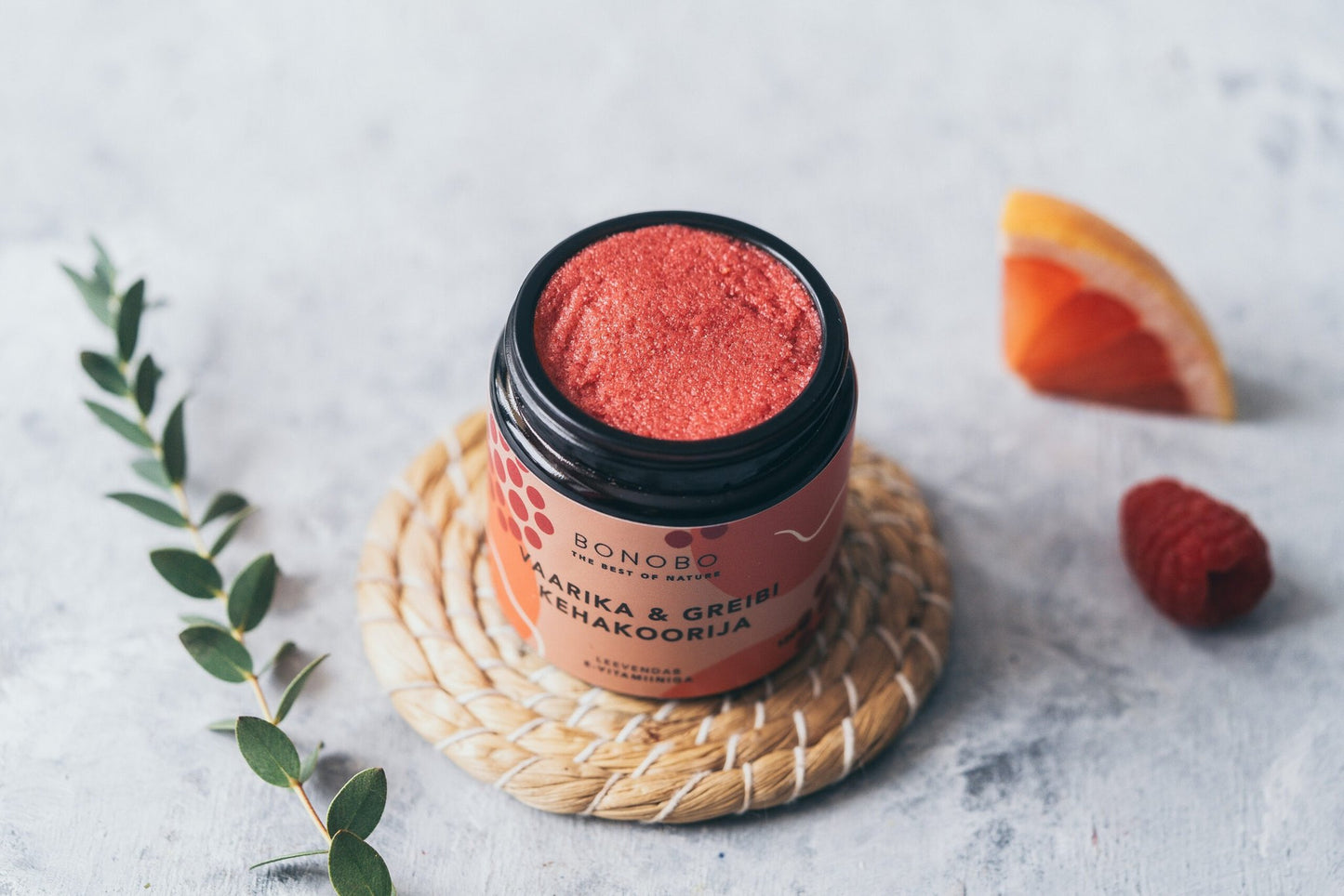 1. BONOBO Raspberry and Grapefruit Body Scrub in jar with natural elements, showcasing vibrant color and texture