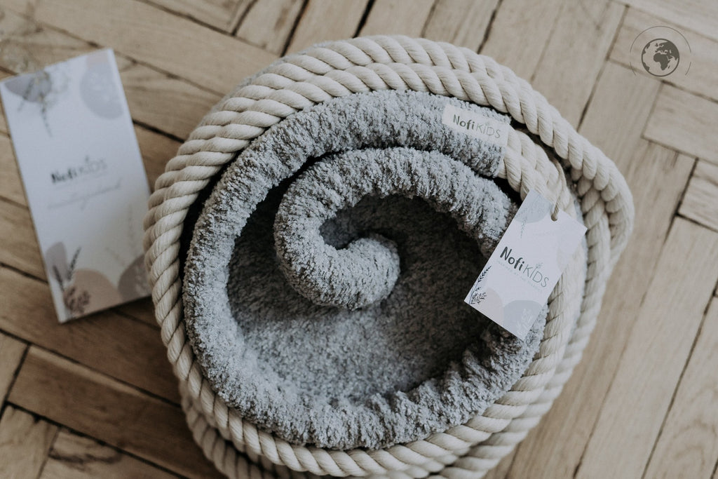 3. Close-up of Nofi KIDS HopOn Swing in bouclé stone grey fabric with cotton rope, showing brand tag on wooden floor