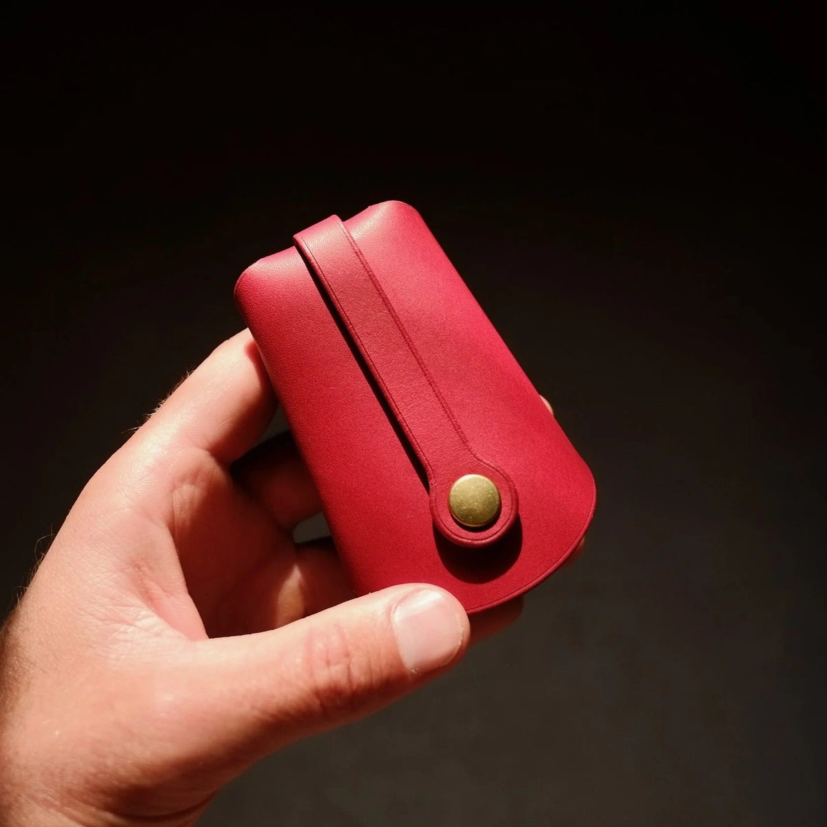 1. Mirgoods red folded keyholder in hand, showcasing compact design and premium leather