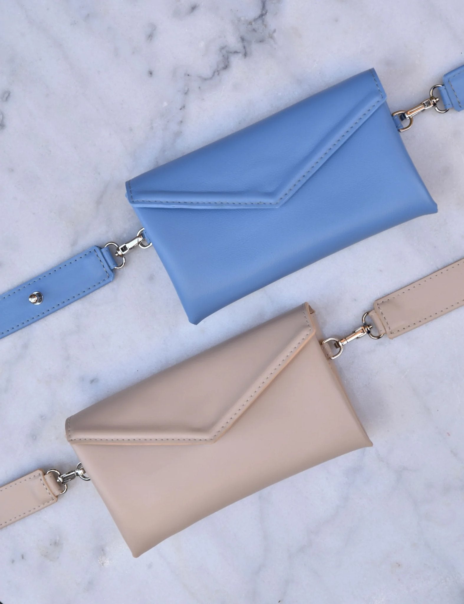 11. Blue and beige Gerda Retter bags with adjustable straps on marble surface