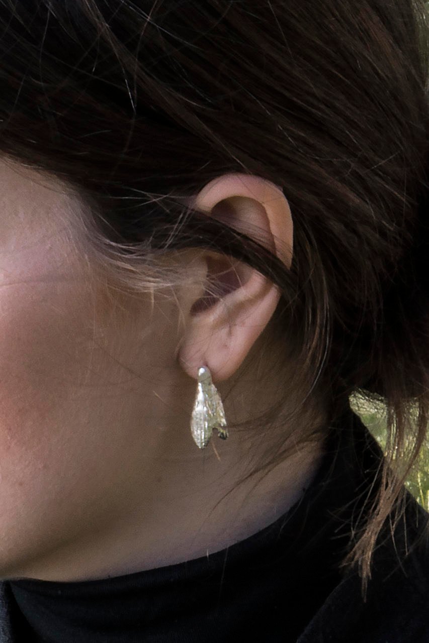 1. Woman wearing Agnes Veski Jewellery SPRING Snowdrops silver earrings, showcasing elegant design inspired by Nordic nature