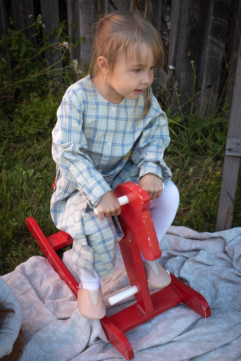 2. Girl on a red rocking horse wearing Hip-Hop Punsa Kids Barefoot Slippers in beige