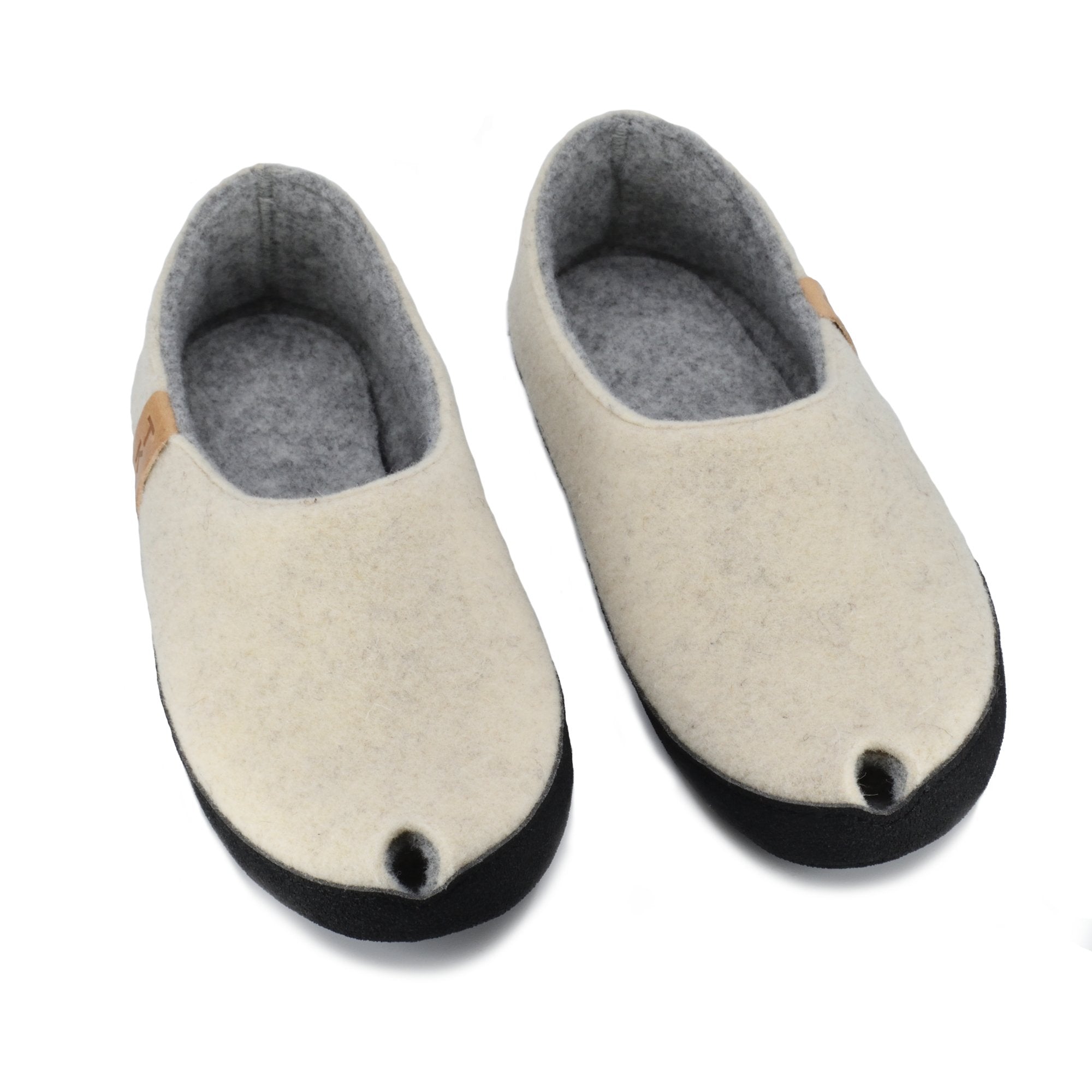 1. TOKU Budapest Slippers in natural white lambswool felt, shown in studio with closed heel and toe design