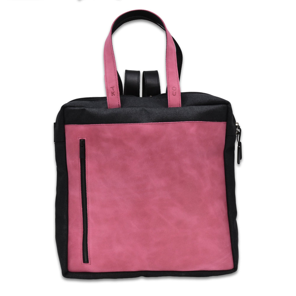 2. Studio image of the Omaking Stockholm Backpack in pink, highlighting the front pocket and leather handles