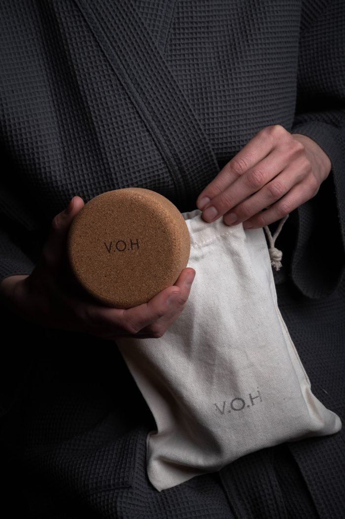 7. V.O.H corkwood case being placed in a branded pouch, emphasizing travel-friendly design
