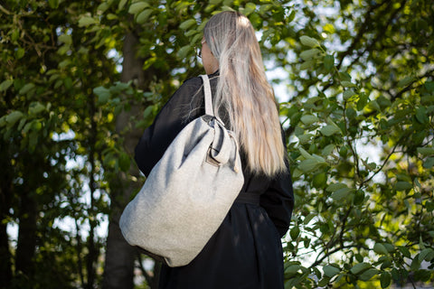 1. Woman wearing Trendbag Märss upcycled bag in outdoor setting, showcasing eco-friendly design