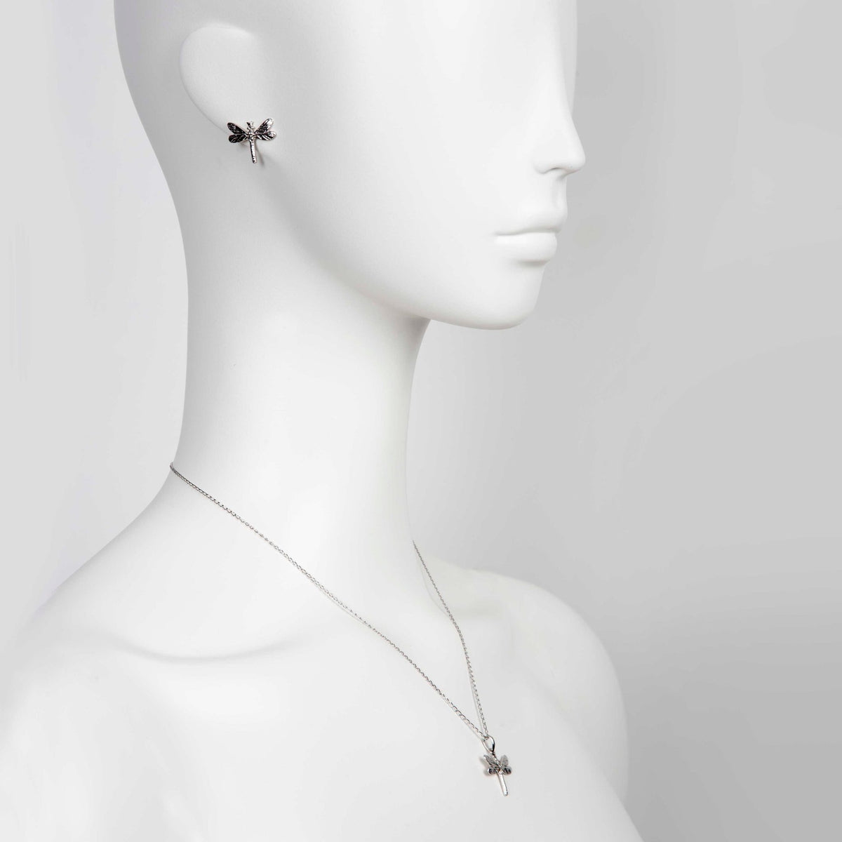 1. Mannequin wearing Tanel Veenre silver dragonfly pendant and matching earring, showcasing elegant design and chain length