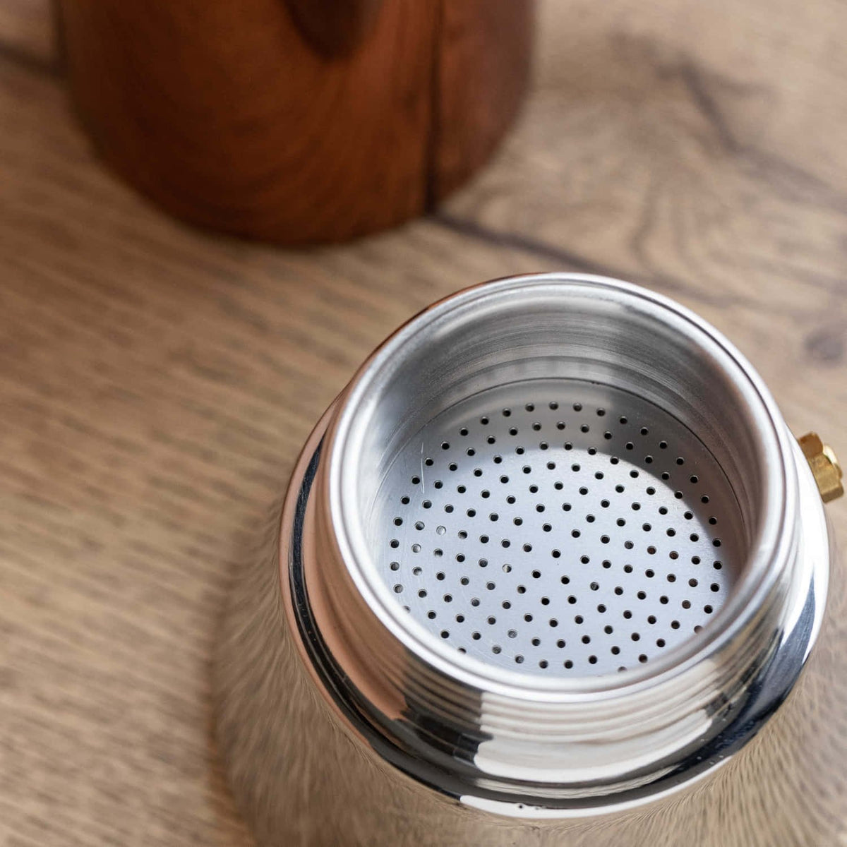 6. Close-up of filter inside La Cafetière silver base on wooden surface