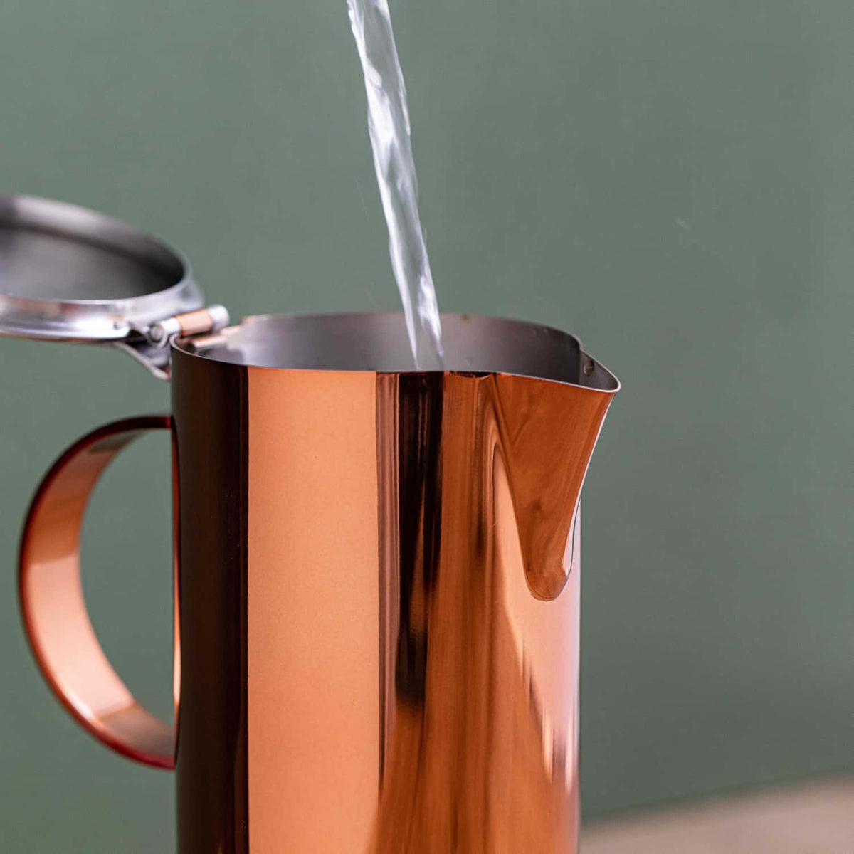 3. Water being poured into La Cafetière copper and silver stovetop coffee maker with open lid