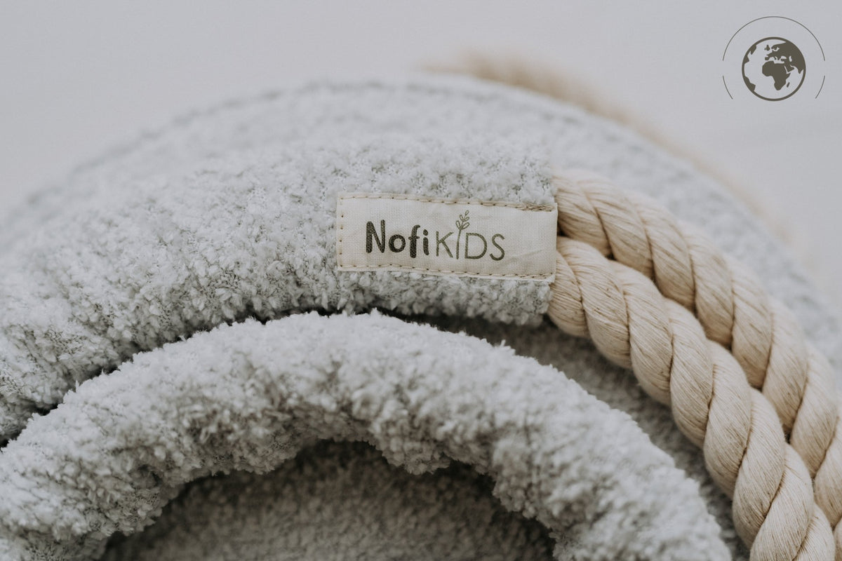 3. Close-up of Nofi KIDS logo on ice grey bouclé fabric with cotton rope detail