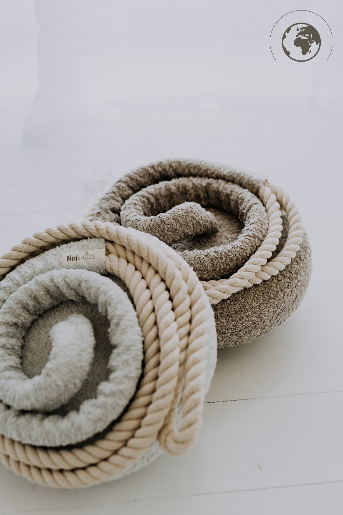 4. Flat lay of two rolled bouclé swings in ice grey and beige with cotton ropes
