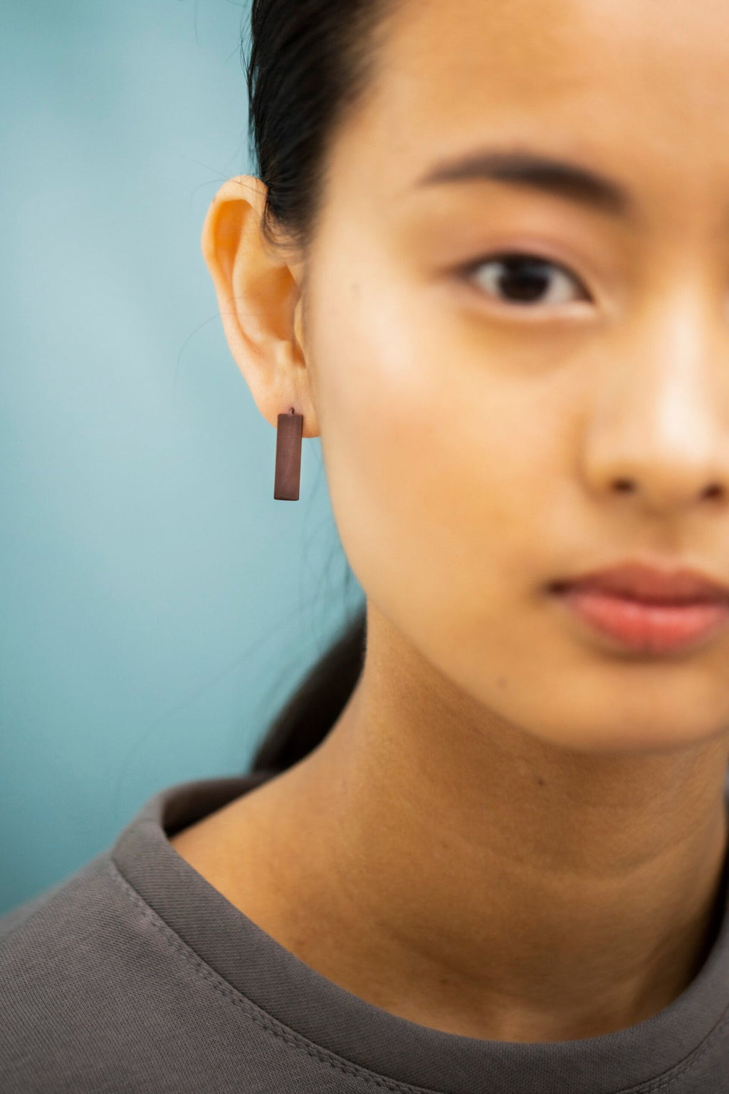 4. Detailed view of Lentsius Corner Purple earring on woman, showing hypoallergenic stainless steel