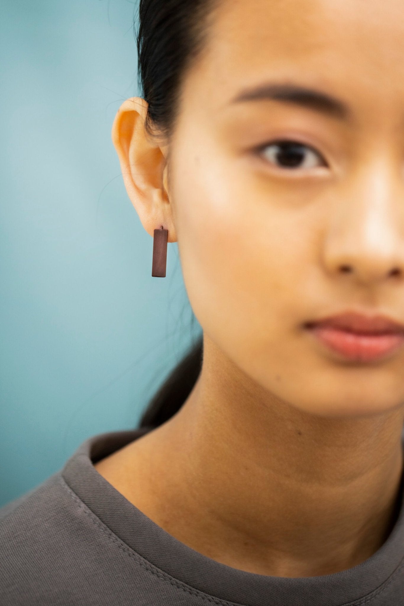4. Detailed view of Lentsius Corner Purple earring on woman, showing hypoallergenic stainless steel