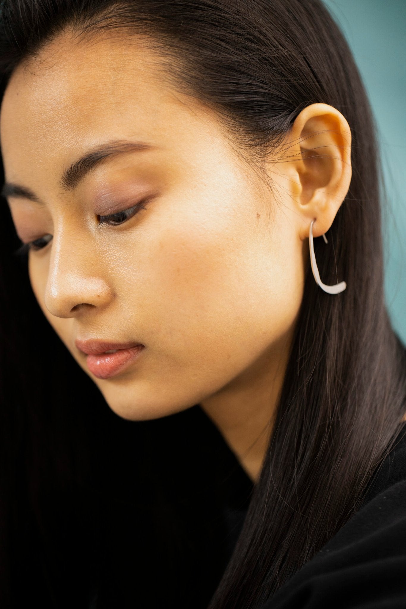 8. Close-up of woman wearing Lentsius Curvi earrings, highlighting secure silicone stoppers