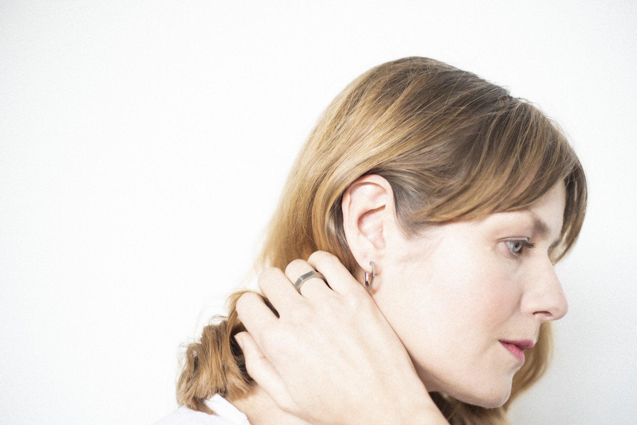 1. Woman wearing Lentsius Flecte earrings, showcasing Scandinavian style in a lifestyle setting