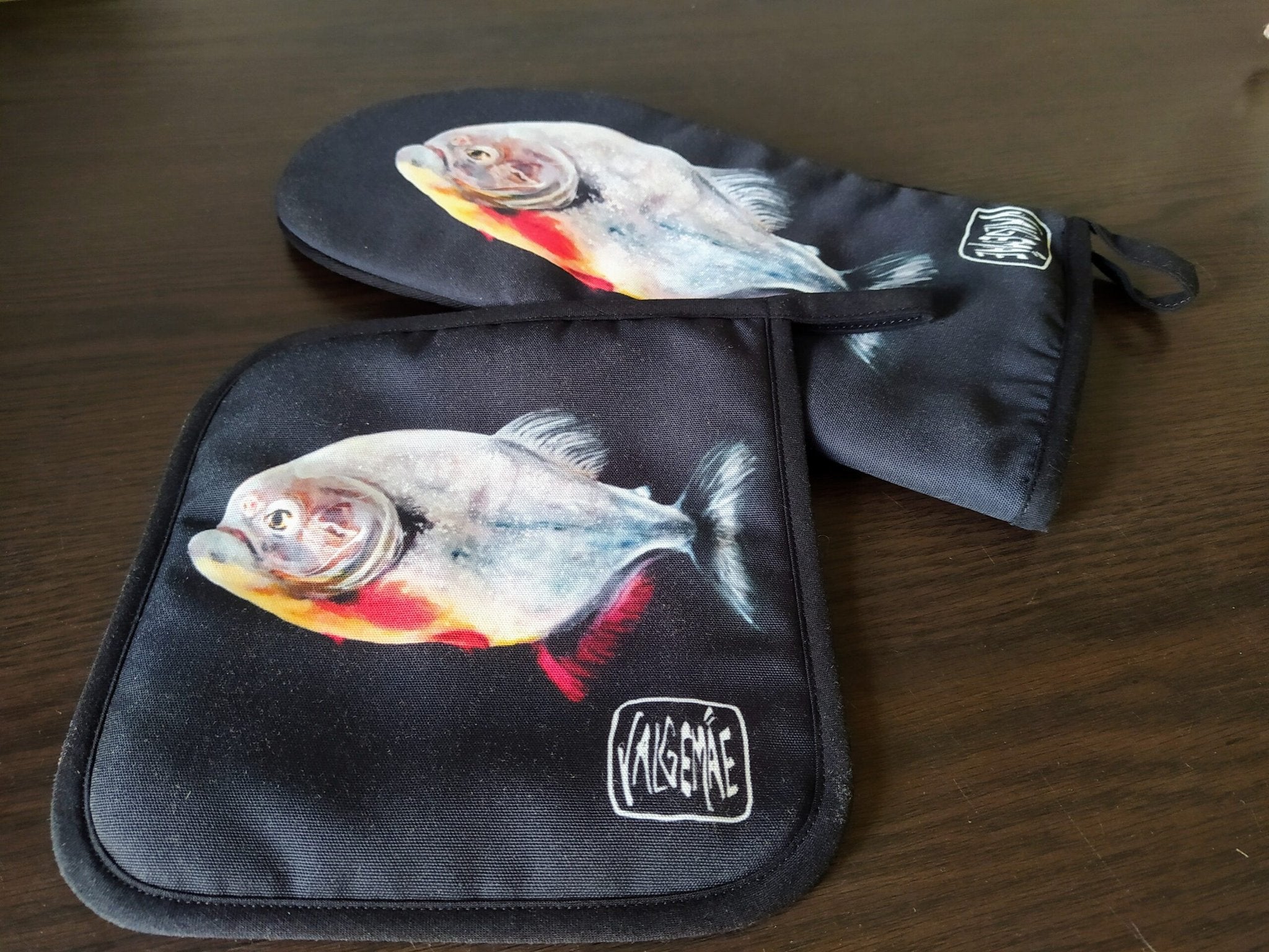 5. Pot holder and oven mitt set with fish painting inspired by Goya, on a dark wooden surface, featuring artist's signature