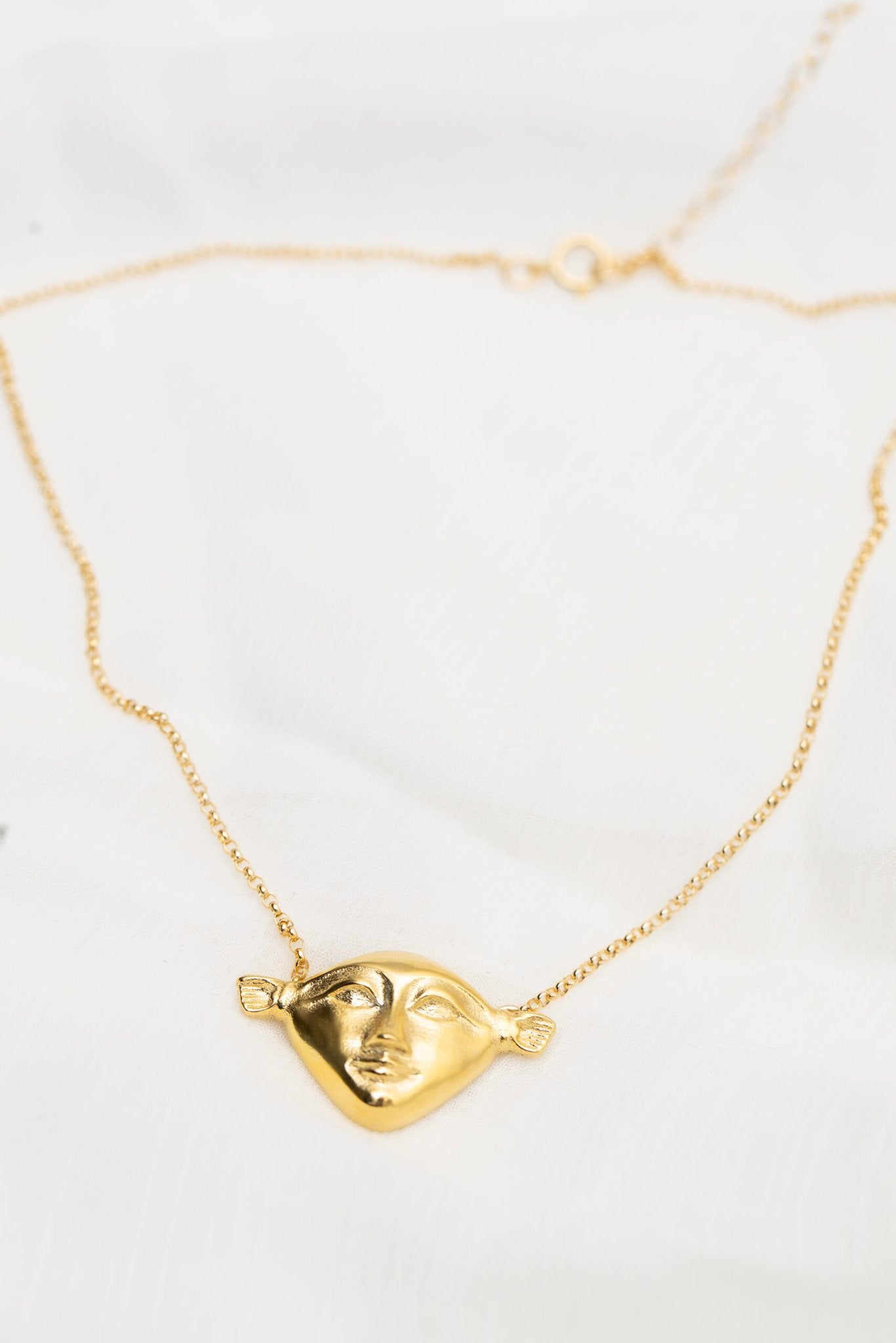 4. Close-up of Hathor Harmony Choker in gold by New Vintage by Kriss, showing pendant detail on white fabric