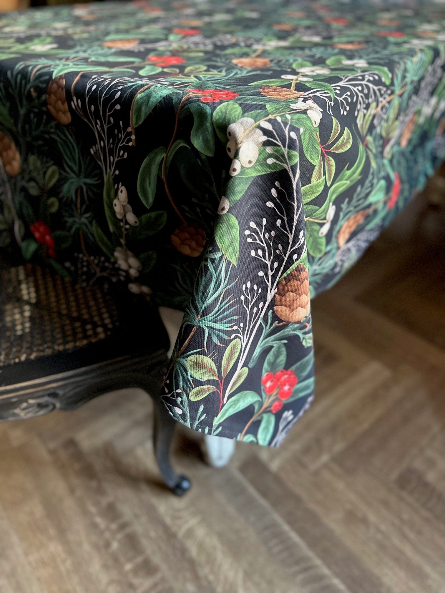 3. Close-up of Hortensias Home Festive Motive Christmas Forest tablecloth, highlighting detailed holiday print with pinecones and berries