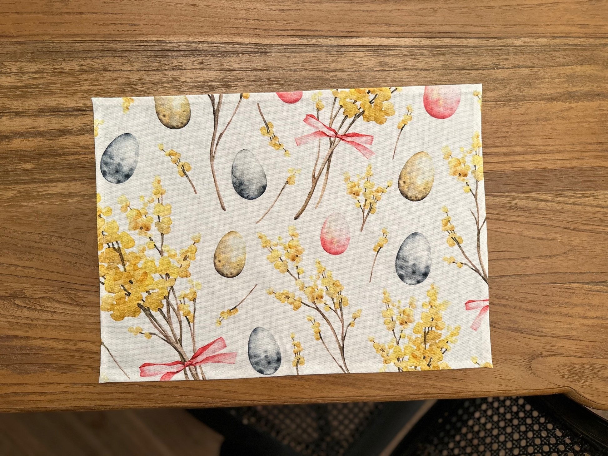 3. Close-up of Easter Happy table placemat by Hortensias Home featuring colorful egg and floral print