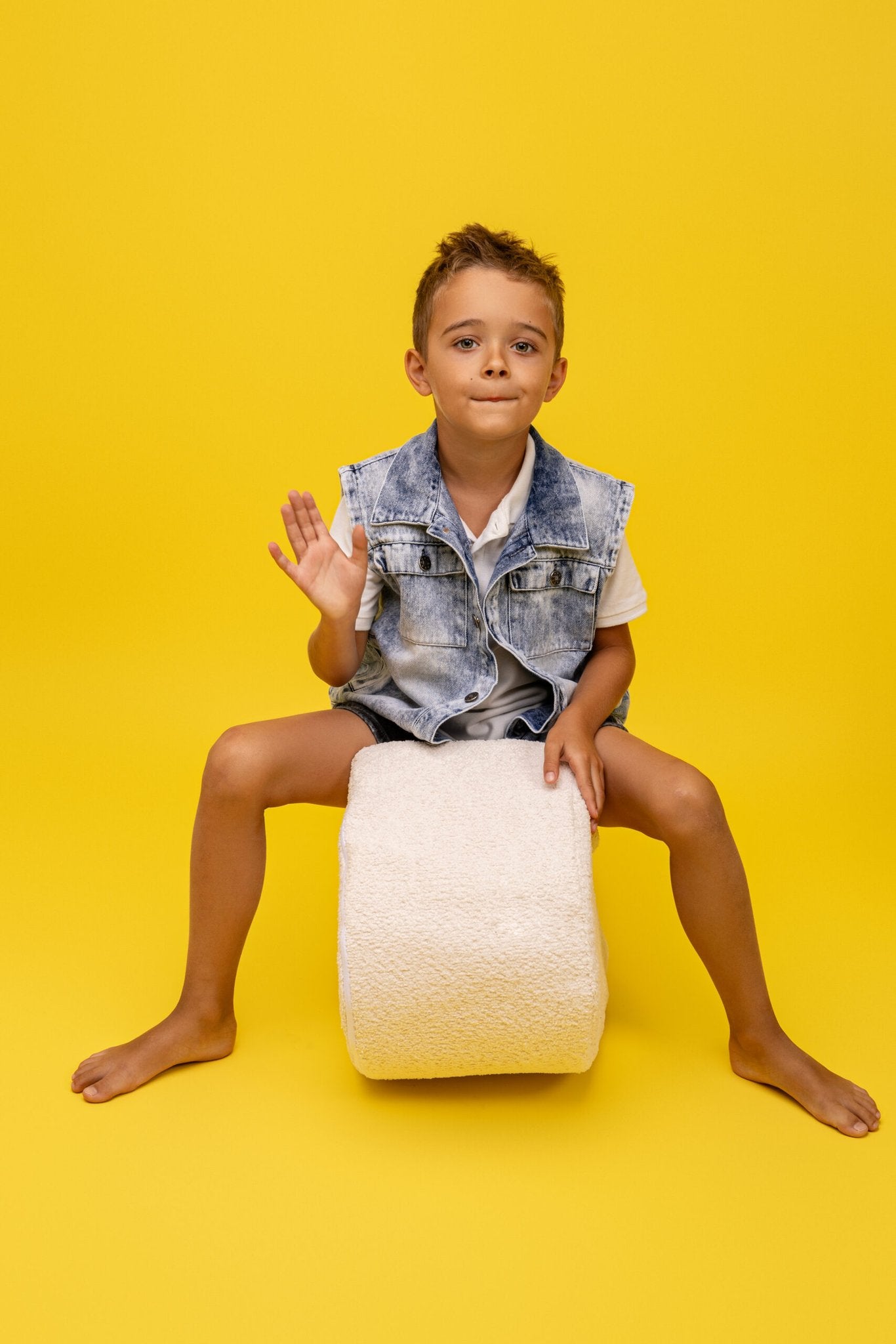 2. Boy sitting on white boucle foam module by MeowBaby against yellow background