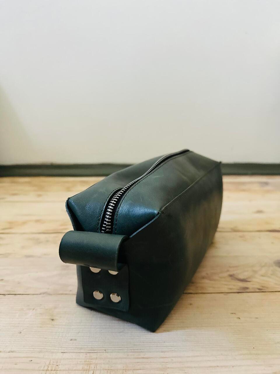4. Close-up of eleriinseim leather cosmetic bag in Forest color showing zippered closure