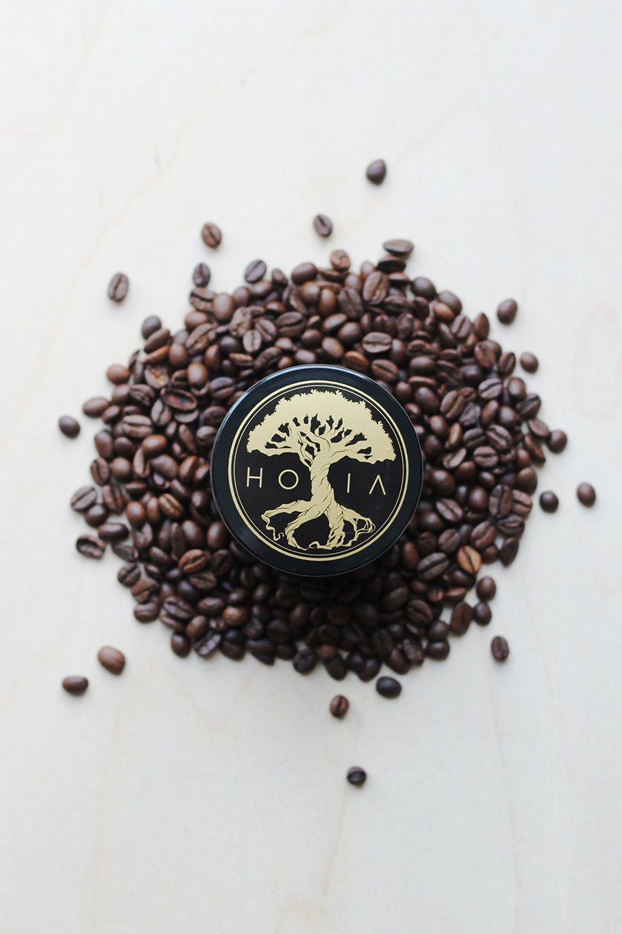 3. Top view of HOIA homespa body scrub jar surrounded by coffee beans