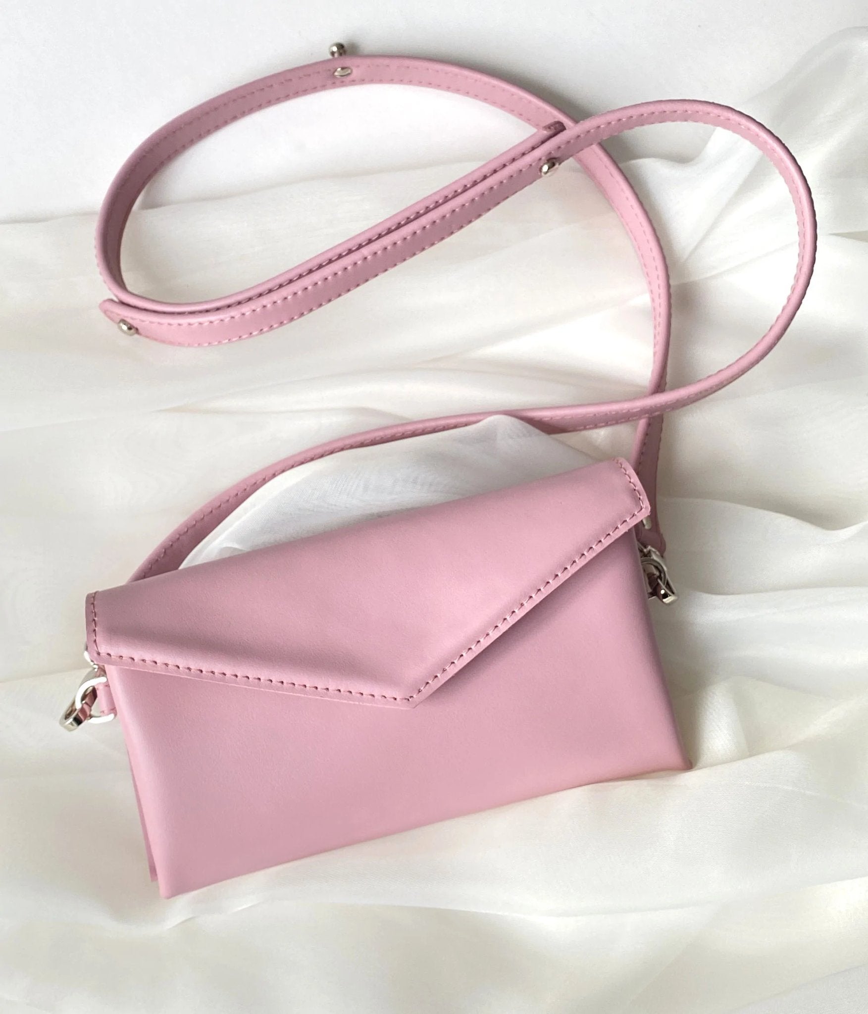 12. Pink Gerda Retter bag with adjustable strap on white fabric background