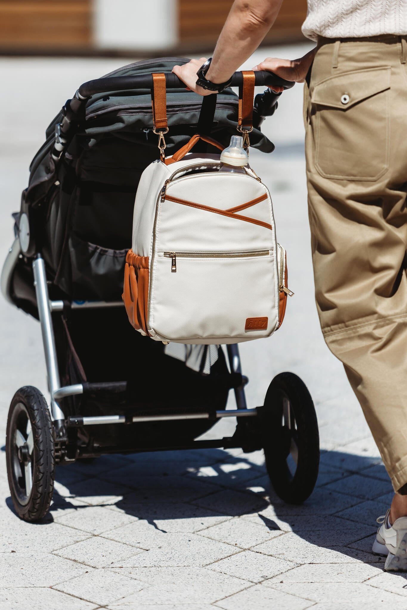 5. Ally Scandic small cappuccino diaper backpack hanging on stroller outdoors