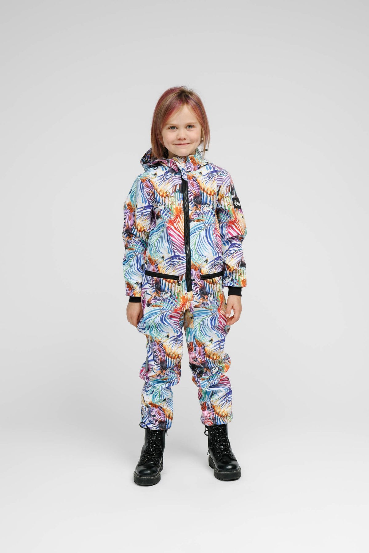 6. Child wearing Nuckö rainbow softshell onesie, facing forward in studio setting