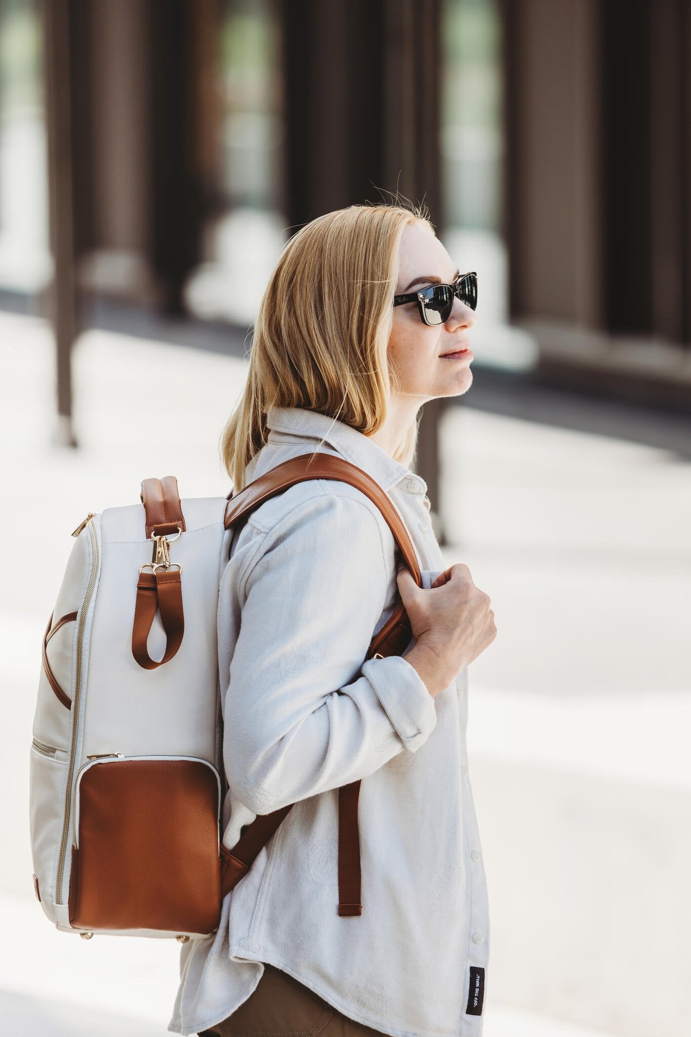 4. Woman wearing Ally Scandic Cappuccino Diaper Backpack, demonstrating comfortable fit