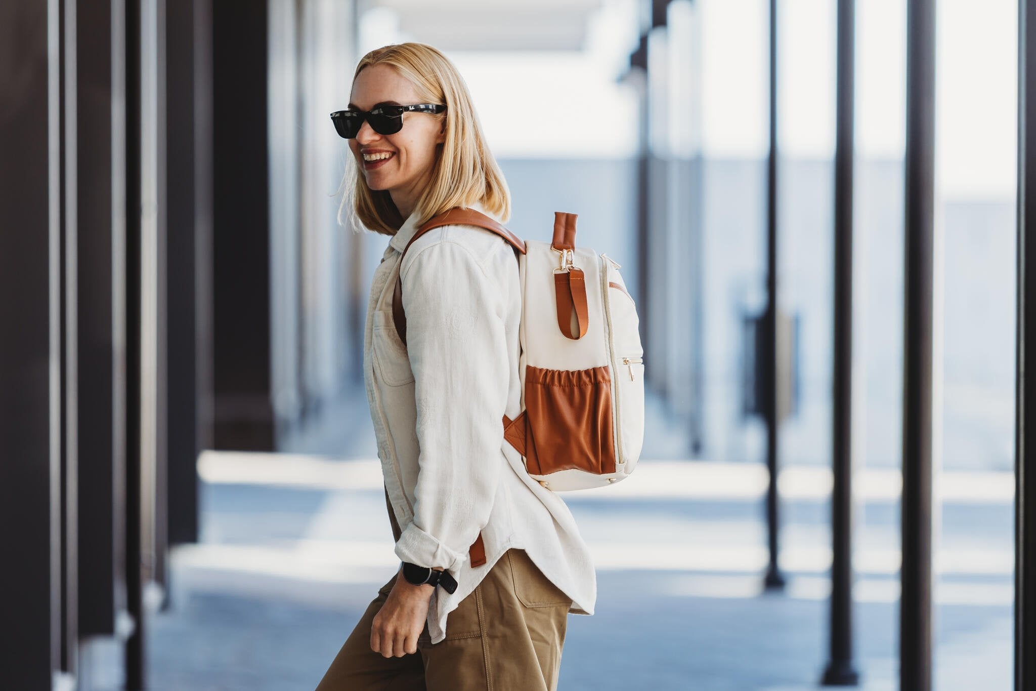 1. Woman wearing Ally Scandic small cappuccino diaper backpack while walking with stroller