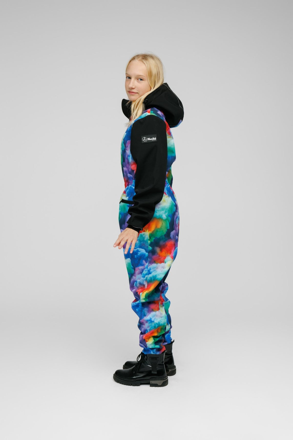 4. Side view of child in colorful softshell onesie with black hood, standing on white background