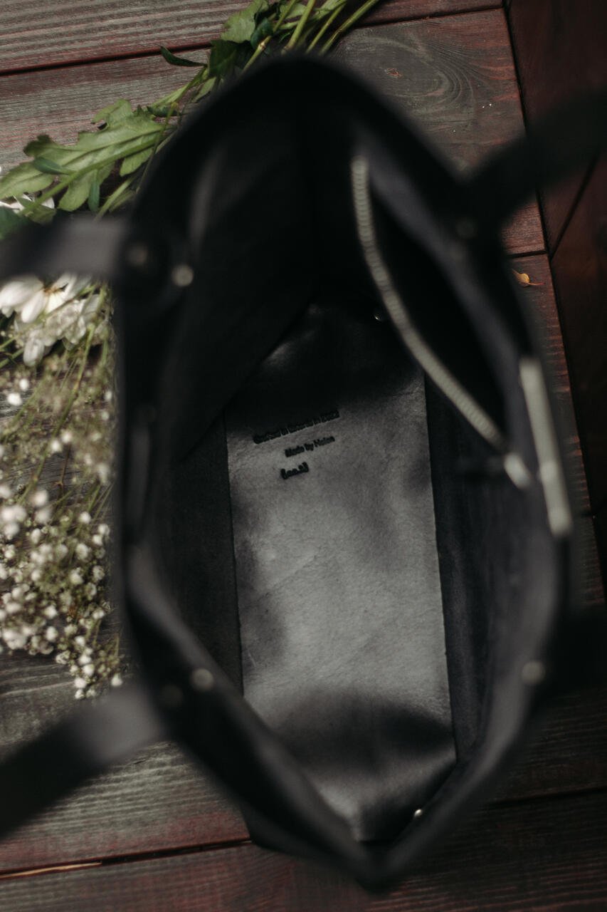 4. Interior view of black leather tote bag by Stella Soomlais with visible zipper and floral decoration