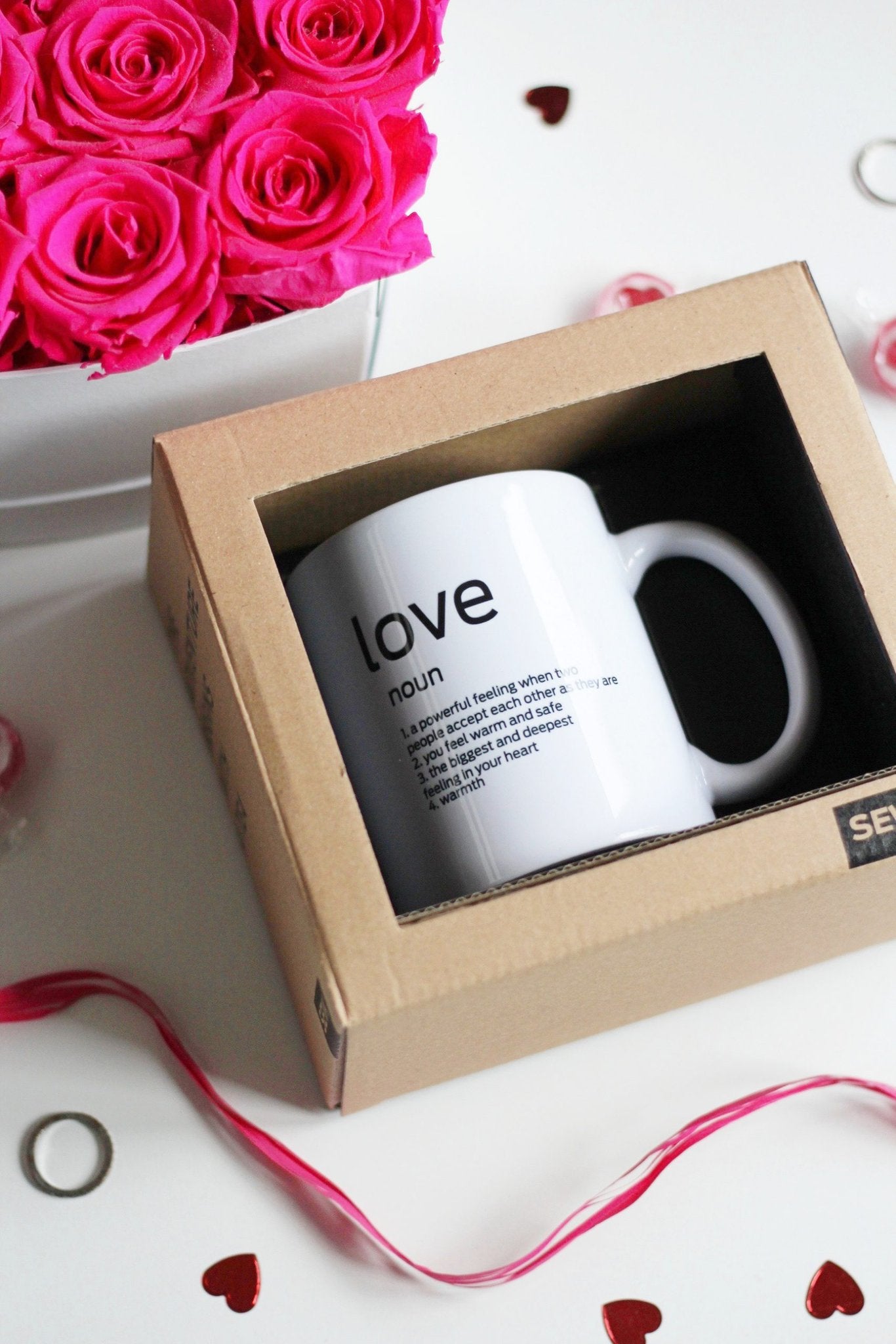 2. SEIK Design Mug with 'Love' definition in packaging, surrounded by pink roses and heart-shaped decor