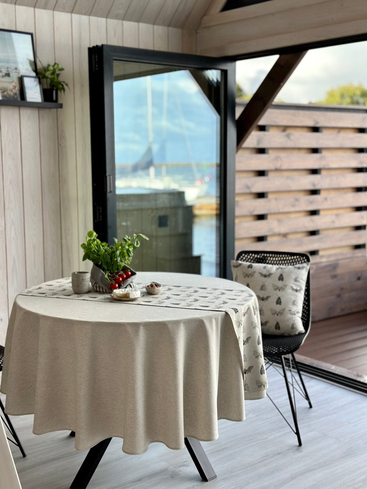 1. Round table with Hortensias Home beige tablecloth in a Nordic-style room, showcasing eco-friendly design