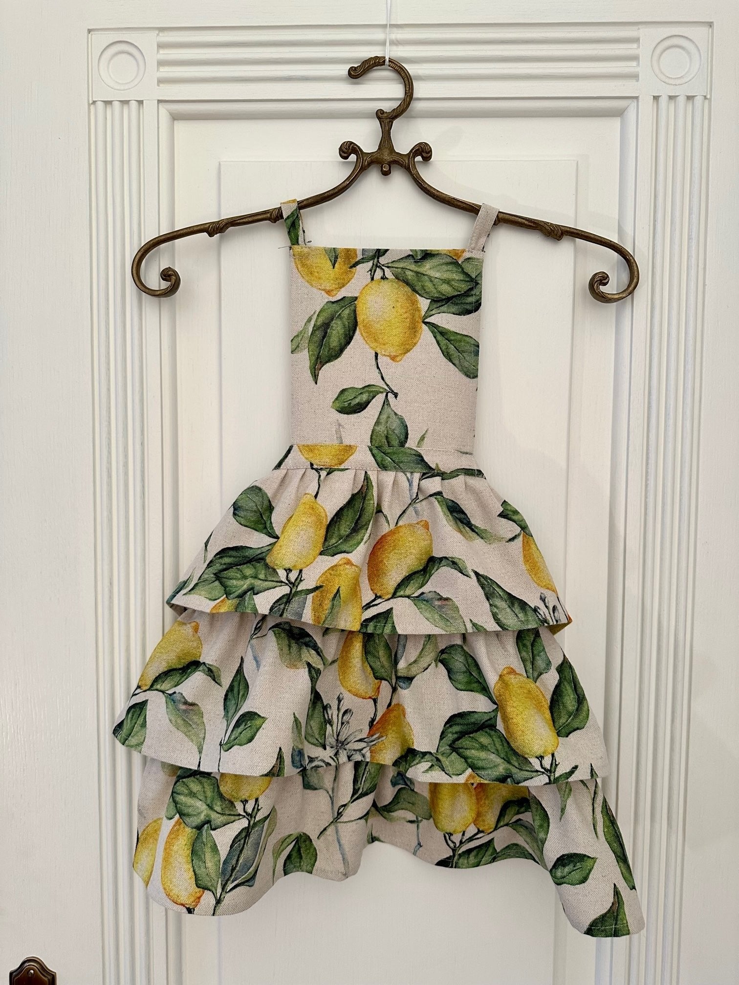 1. Ladies apron with ruffles in lemon print, displayed on hanger, Hortensias Home