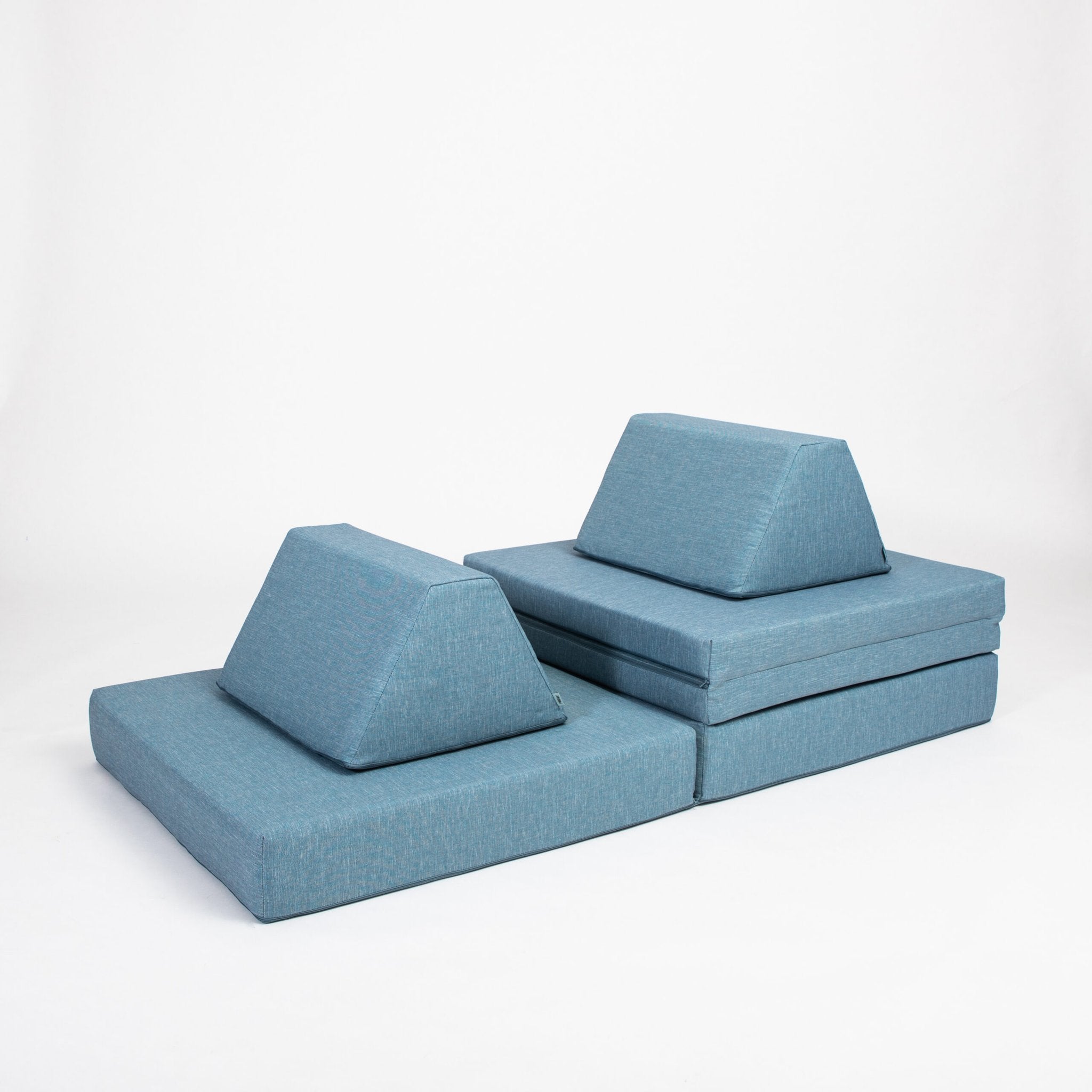 4. Turquoise Monboxy play mattress set arranged with trapezoidal pillows in a studio setting