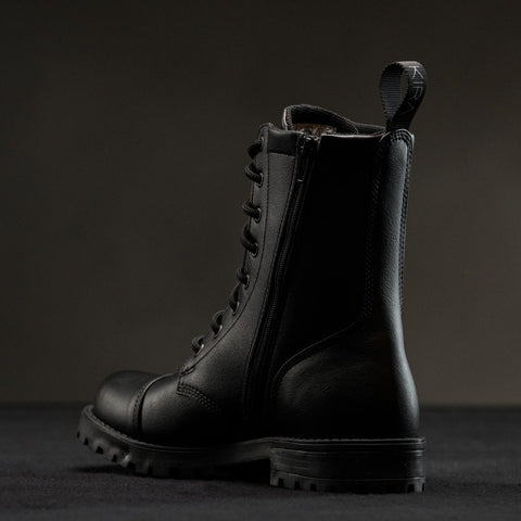 2. Side view of KIRA 6.0 black boots showing zipper and treaded sole, studio setting