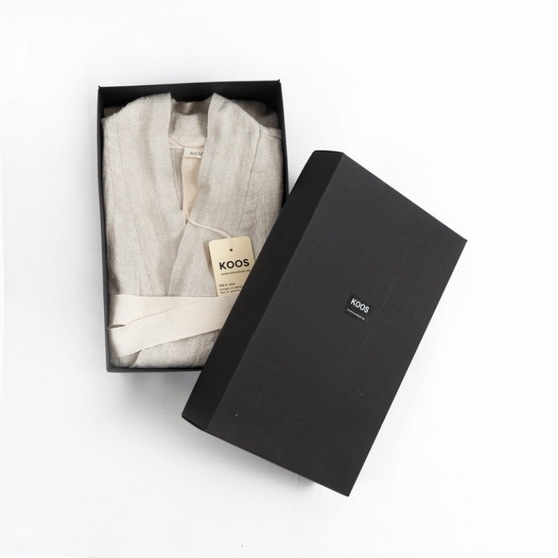 2. Studio shot of KOOSdisain grey linen bathrobe neatly folded in a black box with brand tag visible