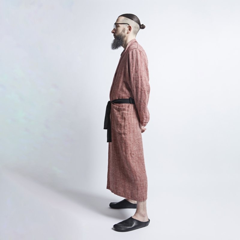 3. Profile of man in red fishbone pattern linen bathrobe with black belt, hands behind back