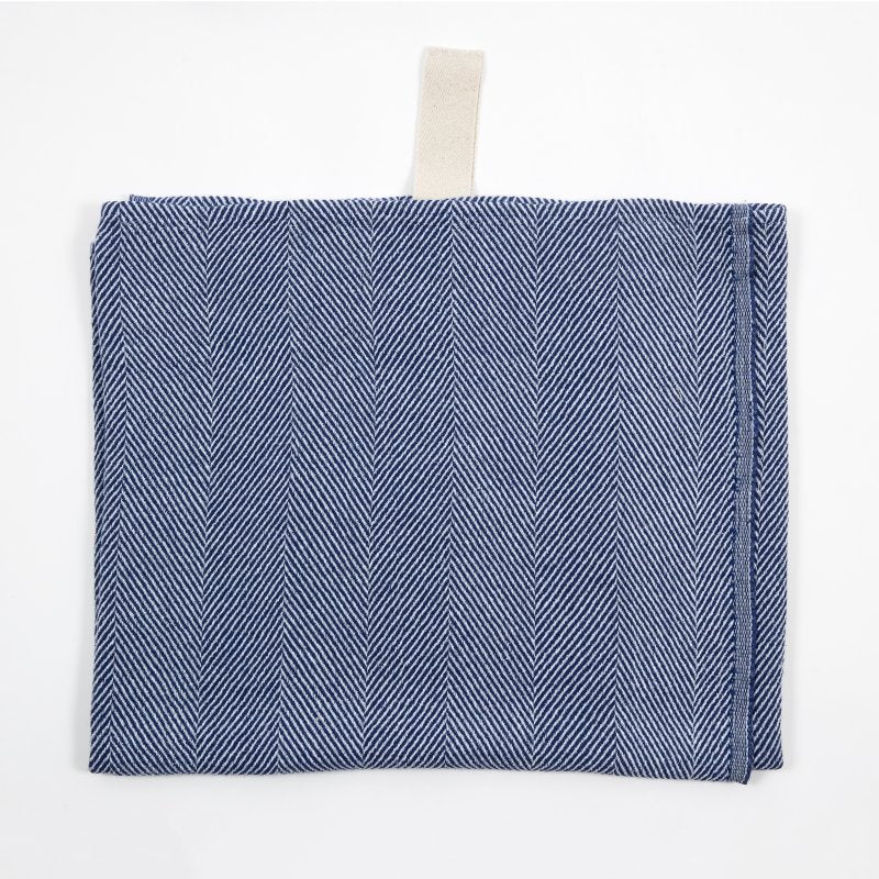 2. Blue linen towel with fishbone pattern and white hanger laid flat on white background