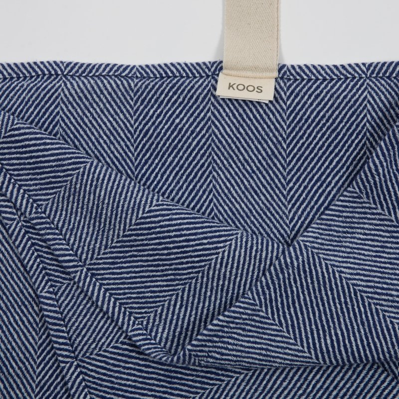 4. Close-up of blue fishbone pattern on linen towel with KOOS label and white hanger