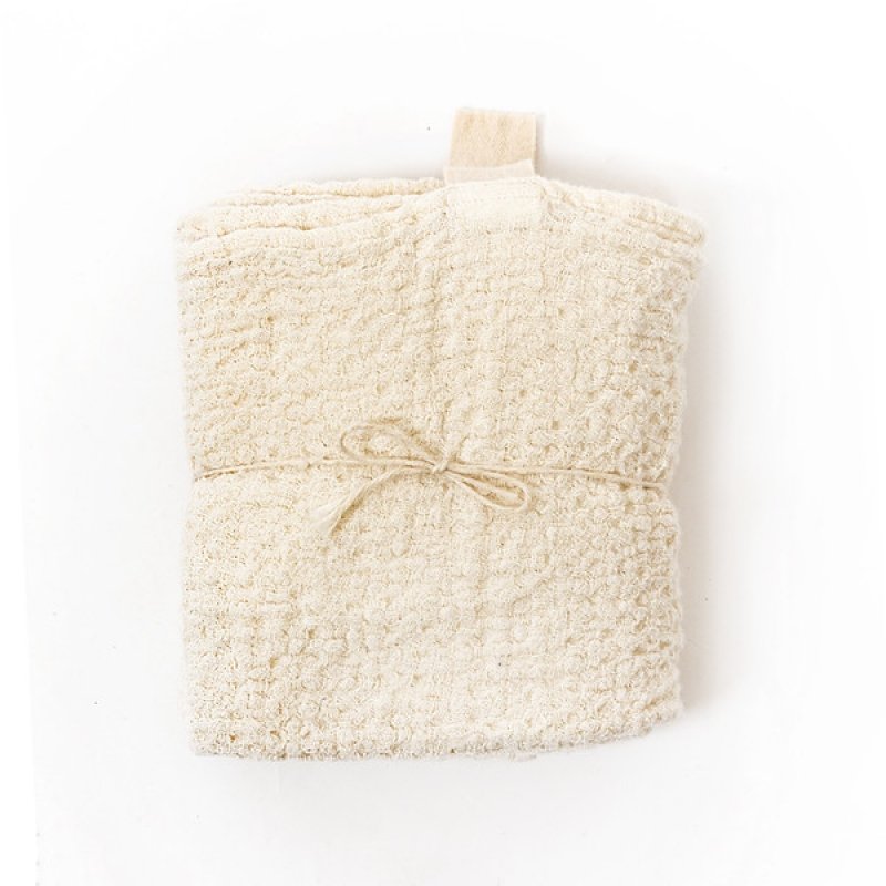 2. KOOSdisain big linen towel in textured white fabric folded and tied with string