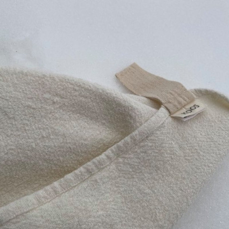 3. Close-up of white linen towel with fishbone pattern and natural band hanger, showing texture and KOOSdisain label