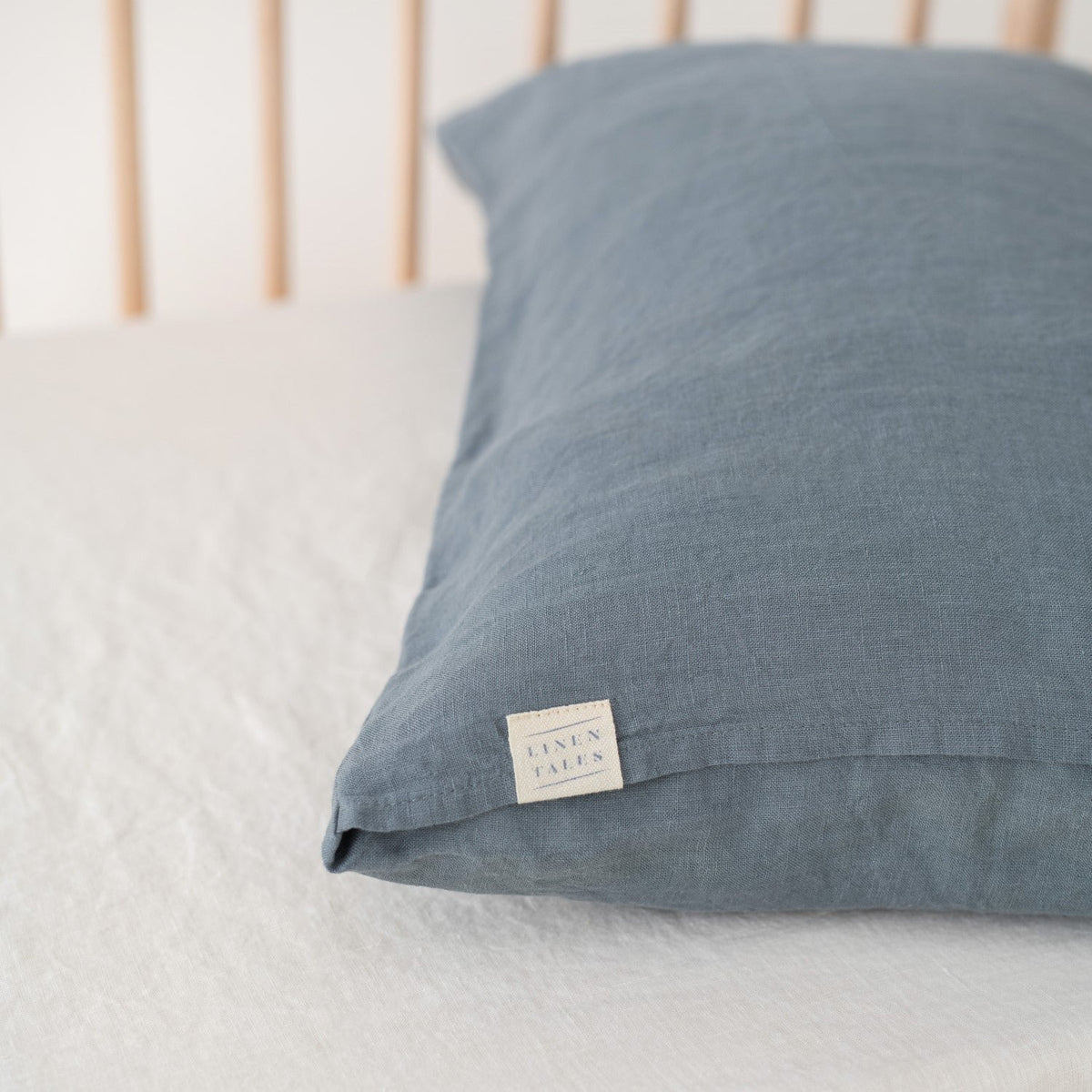 3. Close-up of blue fog linen pillow with Linen Tales label, showcasing fabric texture and brand detail