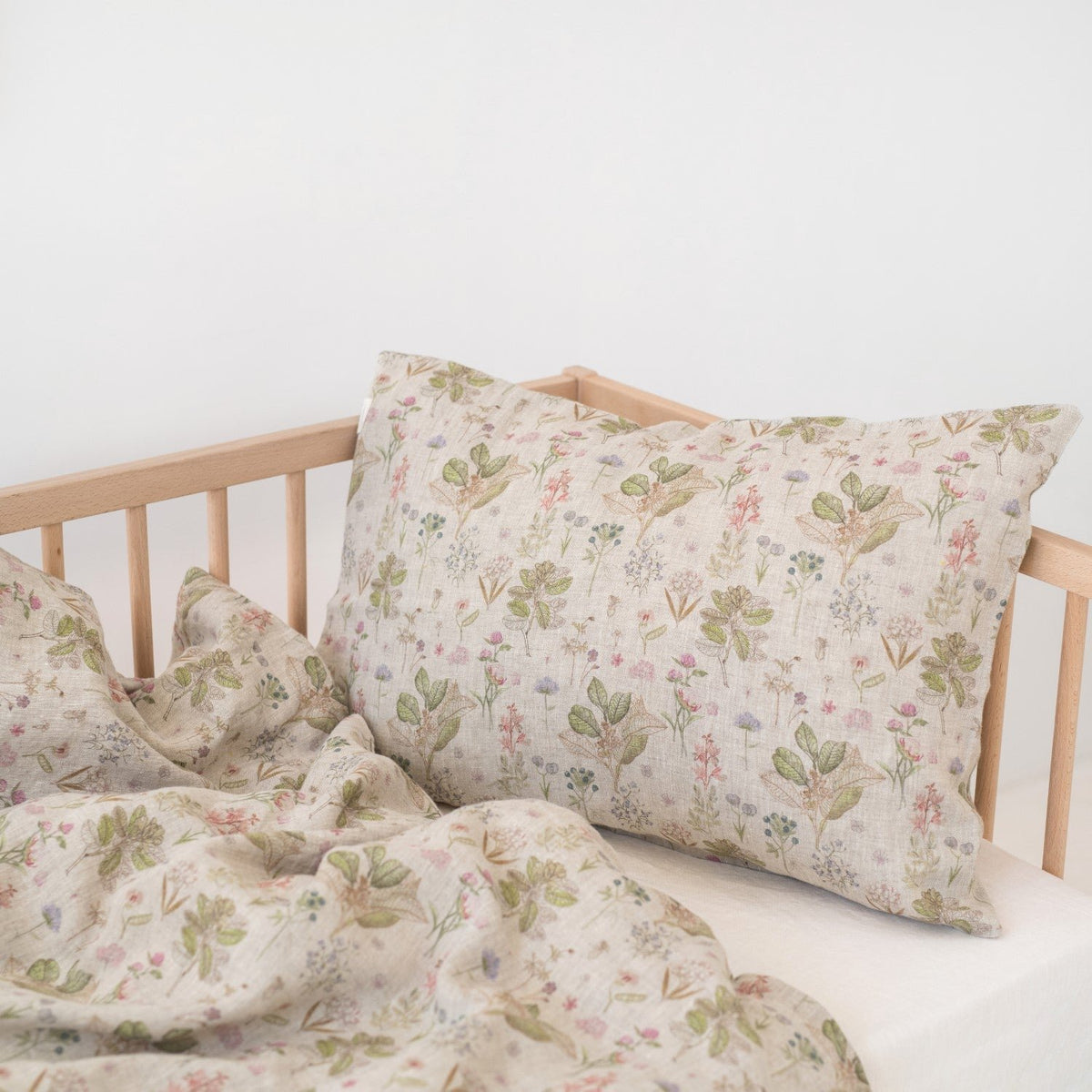 2. Botanical print linen duvet cover and pillowcase on kids' bed in wooden crib