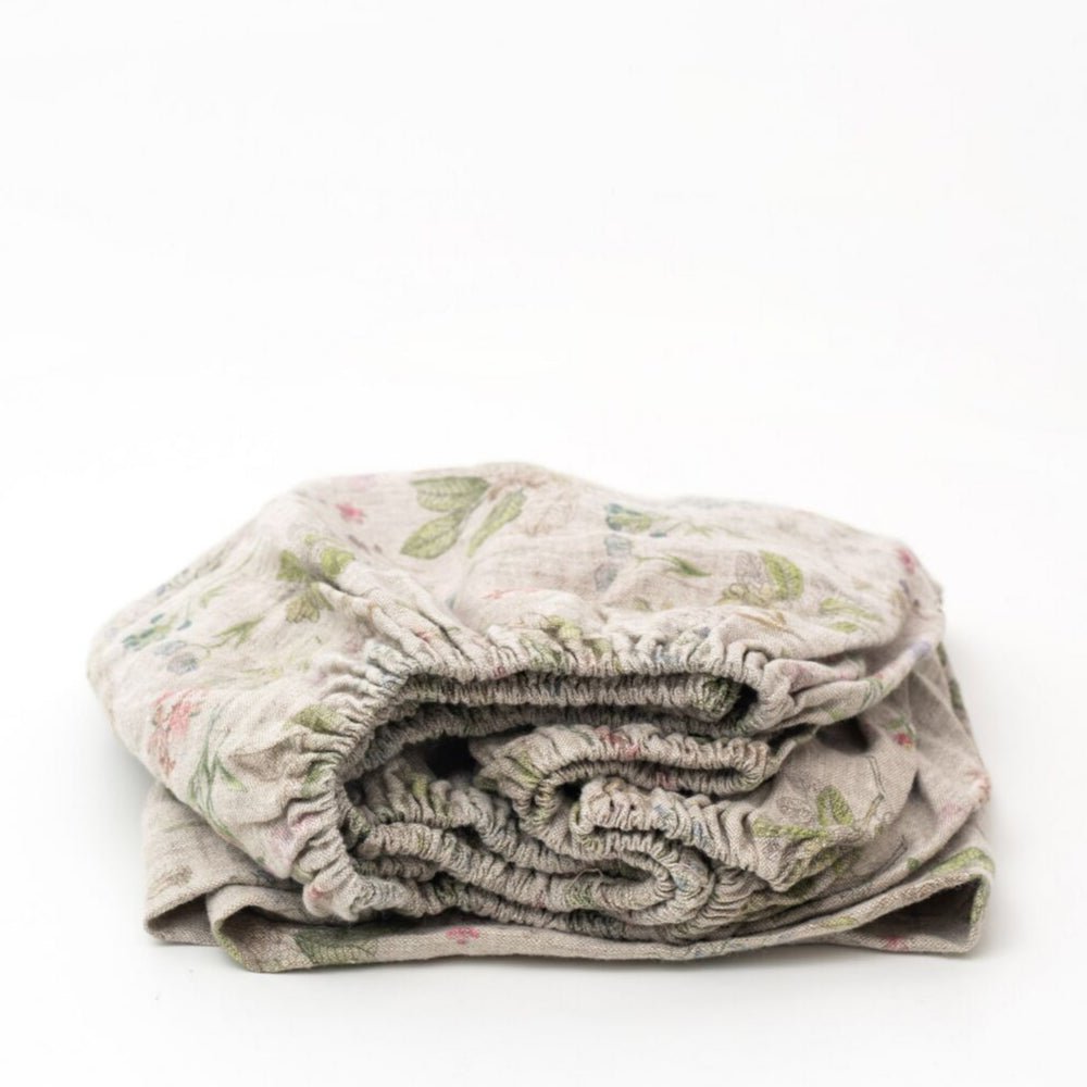 2. Folded kids sage linen fitted sheet with floral print on white background
