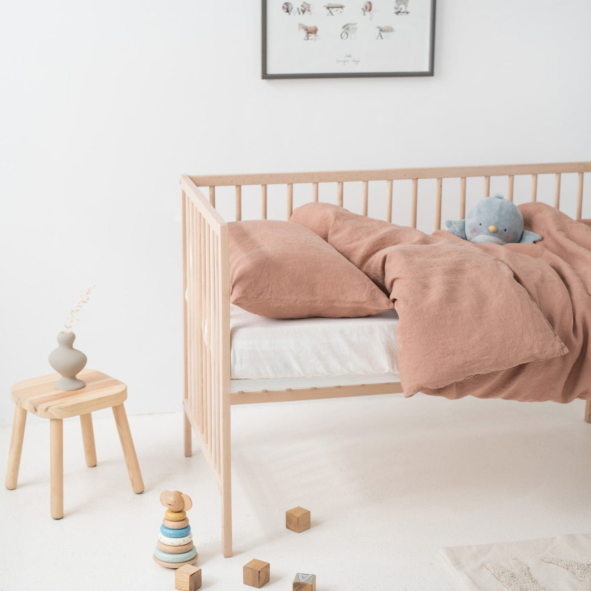 11. Kids' crib with cafe creme linen duvet cover and pillowcase, plush toy and wooden decor in bright room